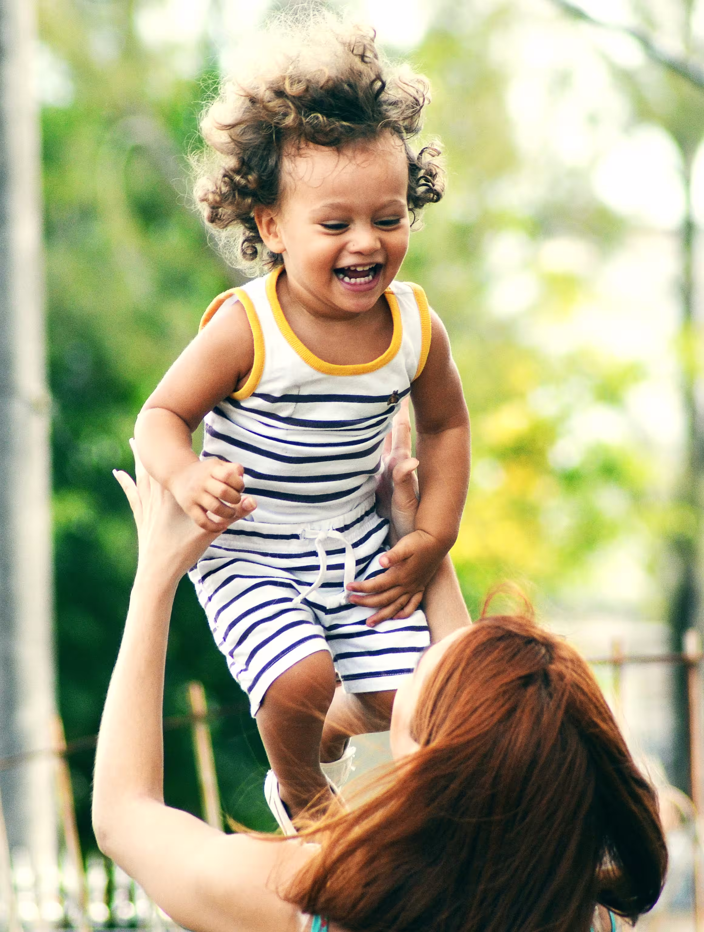 Mom lifting child into the air.